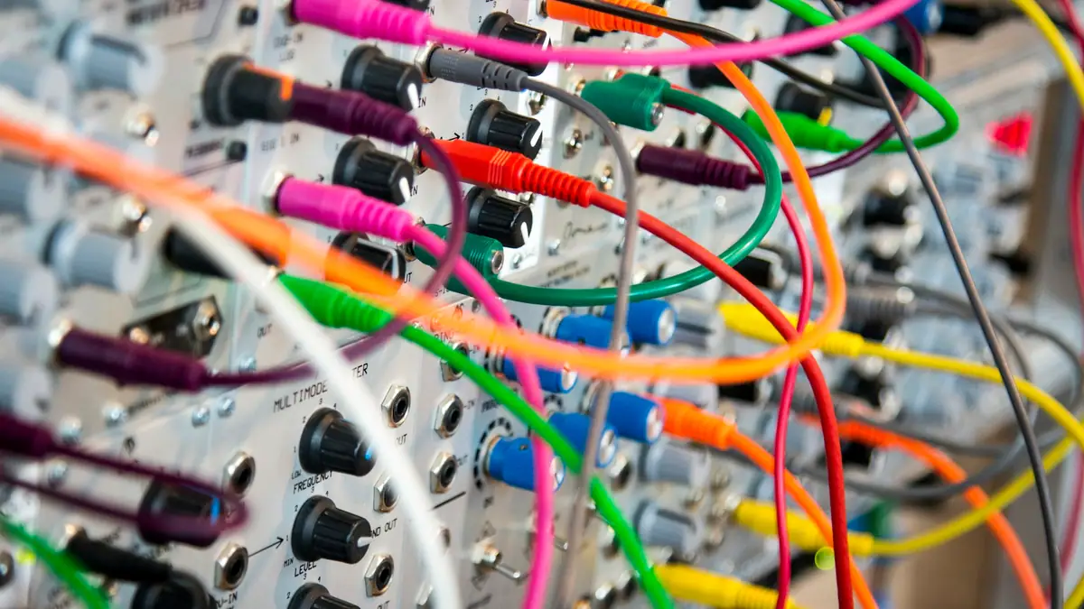Tangle of colored patch cables plugged into a panel