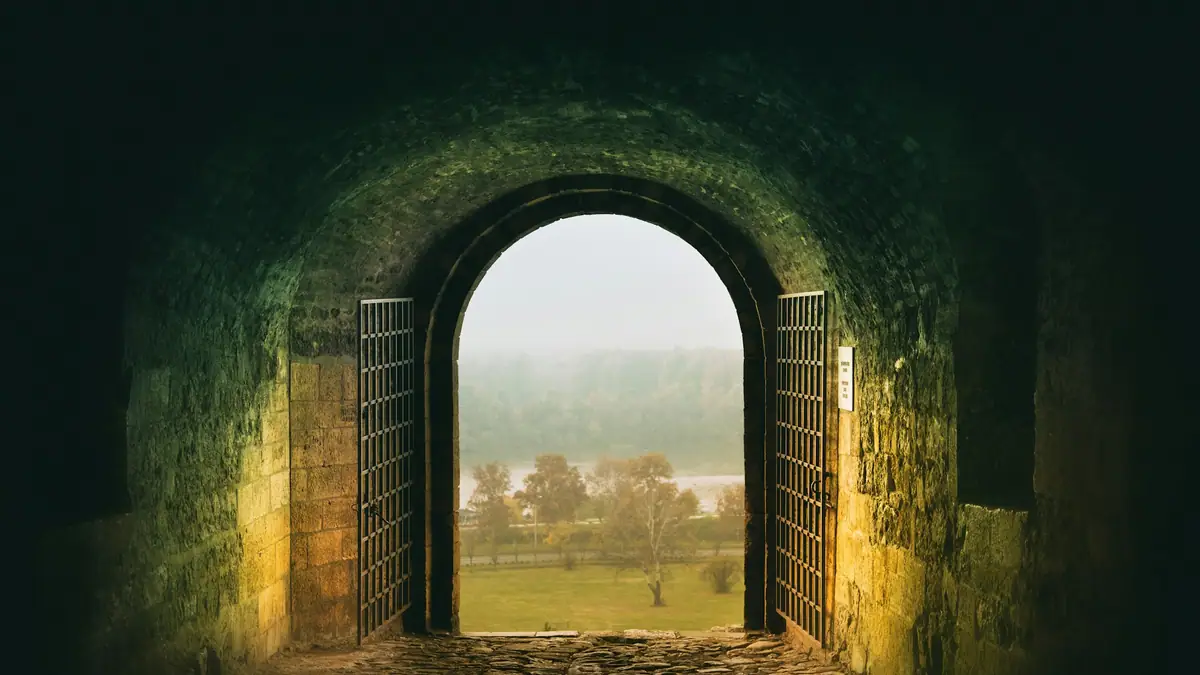 Stone archway opening onto a sunlit field