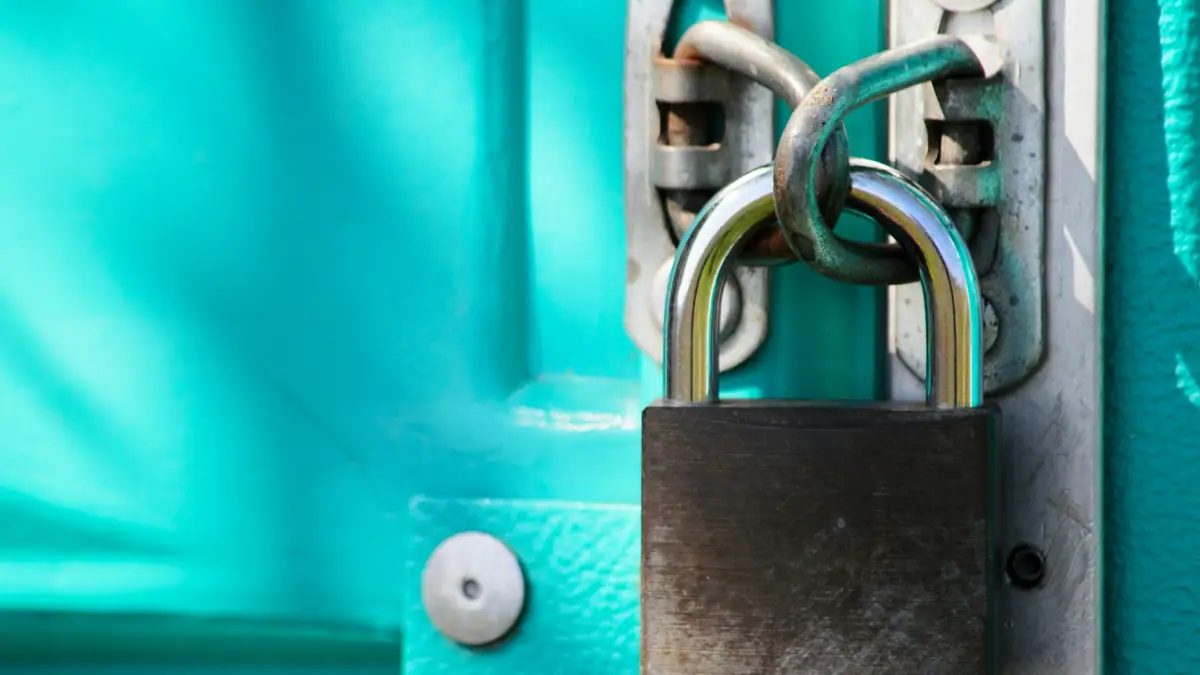 Padlock on a teal metal door